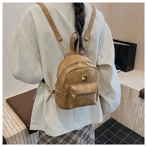 Mini brown retro backpack with gold zippers and slim straps shown on female model
