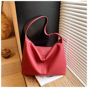 Close-up of red lychee pattern leather texture on a spacious commute tote bag