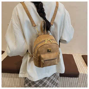 Close-up of vintage brown mini backpack with matte leather texture and gold hardware