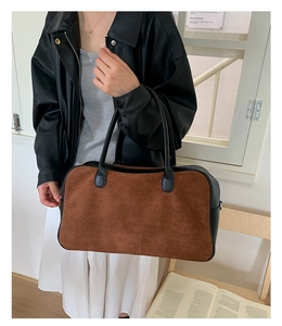 Detail of contrast color tote bag showing brown suede and black leather texture stitching