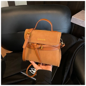 Detail of warm brown frosted leather handbag showing MYBAOB logo and matte texture