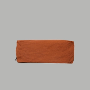 Detailed close-up of water-resistant nylon backpack in retro burnt orange fabric texture