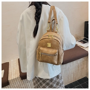 Detail view of khaki retro mini backpack with multi-pocket design and golden metal zippers
