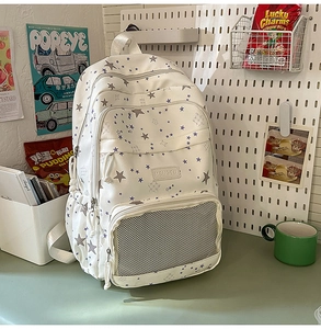 Detail of white backpack with purple star patterns and transparent mesh pocket