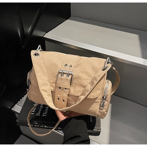 Détail du sac bandoulière en nylon kaki avec boucles métalliques et poches zippées