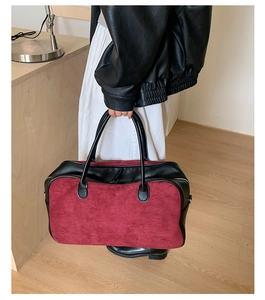 Detail of burgundy suede canvas tote bag with black contrast handles and top metal zipper