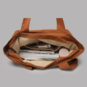 Spacious interior of waterproof caramel tote showing a book and large inner pocket