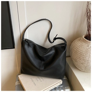 Detailed macro of a black pebble leather hobo bag with a zipper closure and soft texture