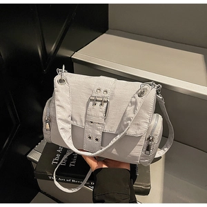 Détail du sac bandoulière en nylon gris clair avec large sangle décorative et boucles argent