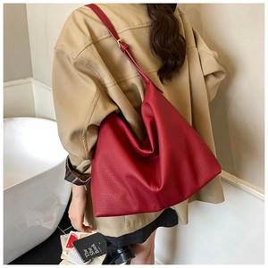 Detail view of large dark red lychee grain leather hobo bag with wide shoulder strap