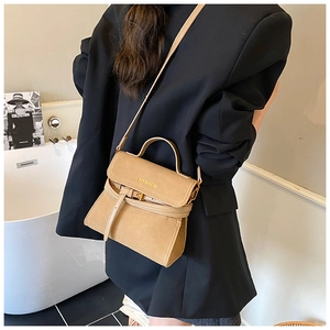 Rear view of brown frosted crossbody bag with top handle and adjustable strap on a model