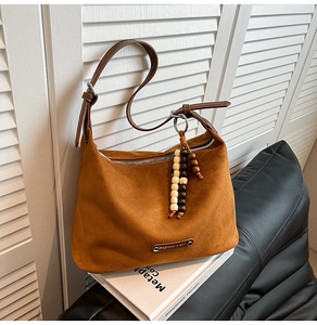 Detail of vintage brown suede dumpling bag with wooden beads and leather strap
