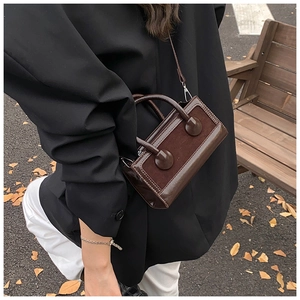 Detail of vintage dark brown crossbody bag with matte and glossy leather texture