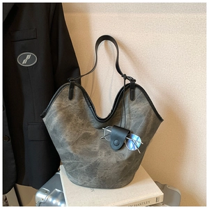 Close-up of vintage grey bucket bag with textured leather and hanging eyewear case