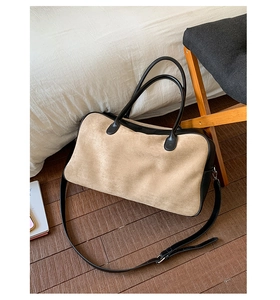 Detail of contrast suede and black leather tote bag on wooden floor for commuting