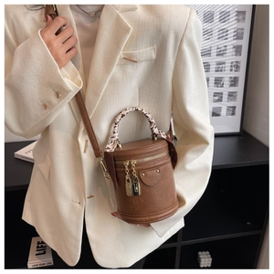 Détail du sac seau cylindrique marron vintage avec poignée en soie et zips cadenas