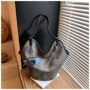 Macro detail of a grey vintage bucket bag featuring a sleek V-cut design and glasses holder