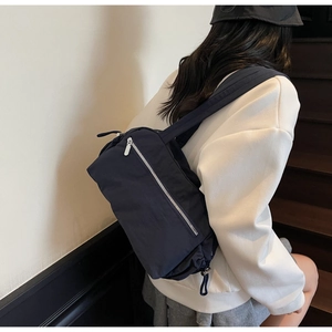 Detail of dark blue nylon shoulder bag with silver zipper pocket and wide strap