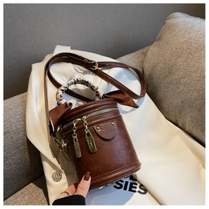 Détail du sac seau cylindrique marron vintage avec poignée en foulard léopard et métal doré
