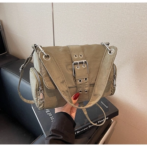 Détail du sac bandoulière vert olive avec grande boucle en métal et poches zippées latérales