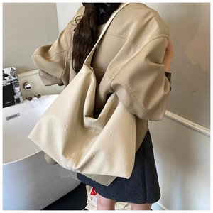 Detail view of large cream hobo bag showing pebbled leather texture and slouchy shape