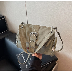 Détails de la besace en toile vert olive avec large bandoulière et boucle en métal argenté