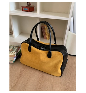 Detail of yellow suede and black leather stitching on large commuter tote bag