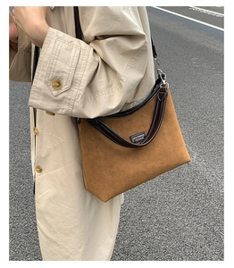 Close-up of brown faux suede crossbody bag with leather handles and Lazy Breeze branding
