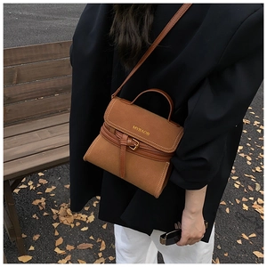 Close-up of brown matte leather crossbody bag with gold MYBAOB logo and buckle detail