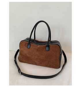 Detail of retro tote bag showing brown suede and black leather patchwork texture