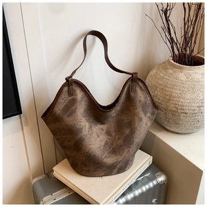 Detail of vintage brown tie-dye shoulder bucket bag on minimalist background
