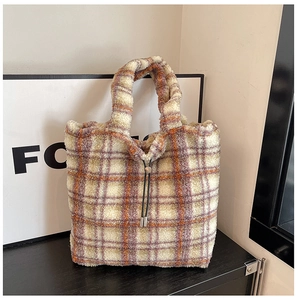 Close-up of tartan plaid fuzzy tote bag featuring plush texture and drawstring metal buckle