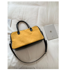 Detail view of large capacity suede tote bag with black leather handles and shoulder strap