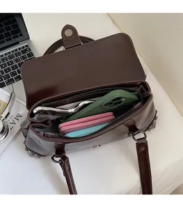 Detail of spacious dark brown leather shoulder bag interior with multiple compartments