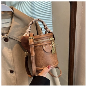 Détails du sac seau vintage marron avec double fermeture et poignée en foulard léopard