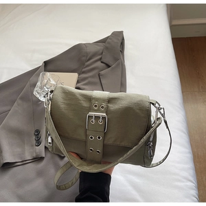 Détail du sac bandoulière olive en toile avec sangle à œillets et boucles en argent