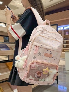 Pink student backpack with star prints and plush charm shown from side-back angle