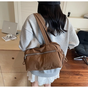Brown nylon tote bag detail with metal zipper pocket and wide comfortable shoulder strap