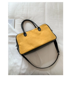 Detail view of yellow suede and black leather patchwork tote with adjustable strap