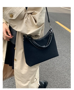 Close-up of black matte canvas shoulder bag with silver hardware and leather trim details