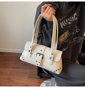 Detail of off-white PU leather shoulder bag with vintage rivets and buckle strap