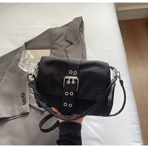 Gros plan d'un sac en toile noir avec sangles à œillets argentés et boucles en métal