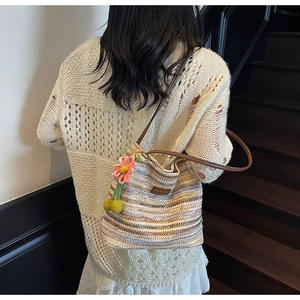 Detail der gestreiften gewebten Beuteltasche mit Lederband und Strickblumen-Anhänger