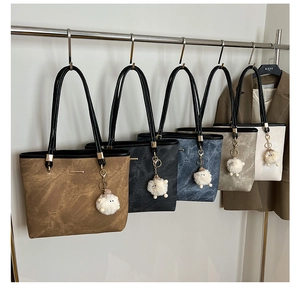 Detail view of large tote bags in five colors with cute lamb charms and metal hardware
