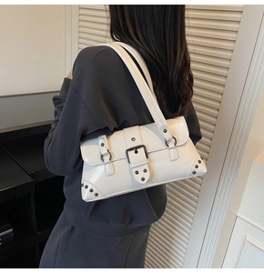 White retro shoulder bag with glossy finish and rivet details shown on model