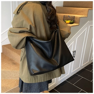 Detail of black pebbled leather tote bag showing soft texture and natural luster