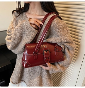 Detail of dark red vintage underarm bag with silver buckle and metallic rivets