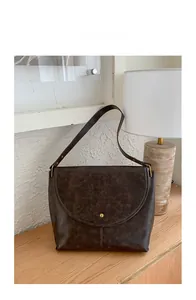 Détail du cabas vintage marron foncé montrant le bouton doré et la texture du similicuir