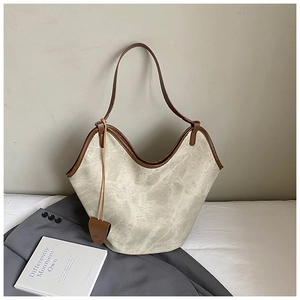 Detail of retro large capacity bucket bag featuring ivory rock texture and brown leather straps
