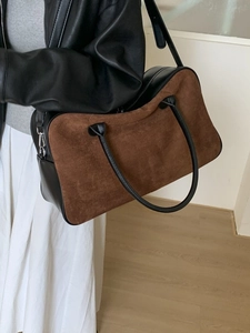 Two-tone matte suede and leather tote bag shown on model in minimalist interior